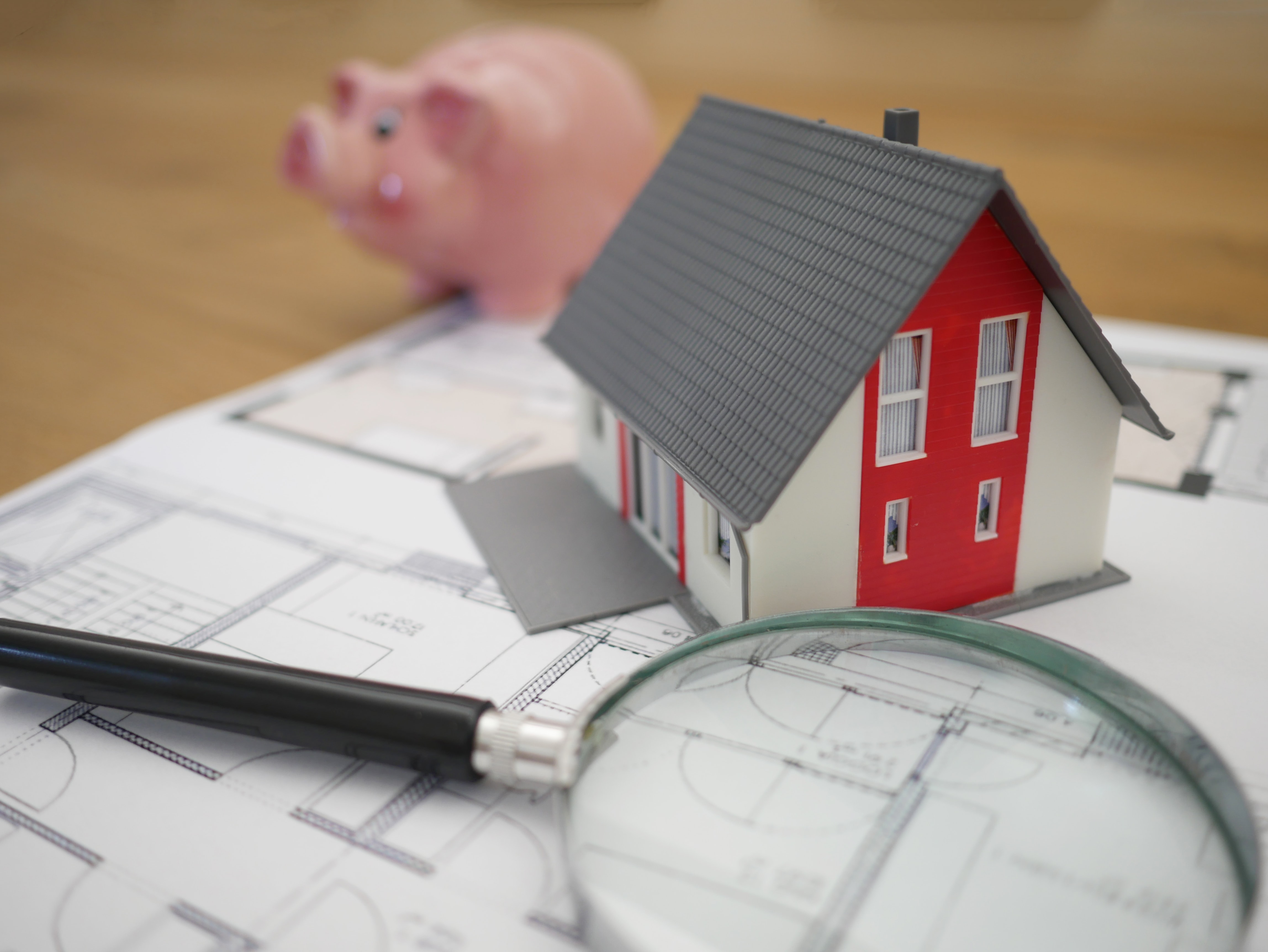 Modellhaus mit Lupe – Immobilienbewertung in Pforzheim
