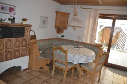 Kachelofen und Essecke und Zugang zum Balkon